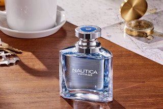 a blue bottle of cologne on a wooden table 