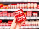 hand holding two boxes of tylenol caplets in walmart aisle