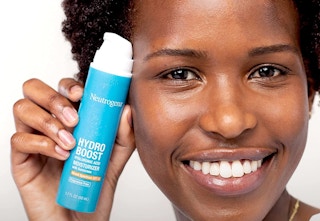 A woman holding a sunscreen bottle