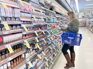 woman shopping for makeup holding a walgreens basket walgreens