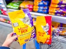 Meow Mix Cat Food in a Walmart cart and held by hand