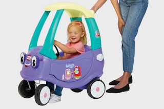 Little girl inside Bluey Little Tikes Coupe Car being pushed by mom