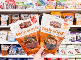 hand holding two bags of rachael ray dog treats