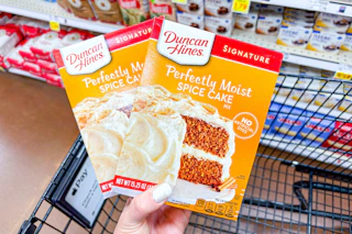 hand holding boxes of duncan hines cake mix
