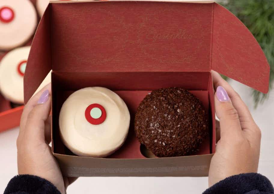 two cupcakes sitting side by side held in a red box