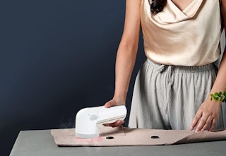 person using fabric shaver on clothing