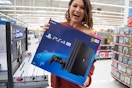 A woman holding a playstation 4 inside Walmart