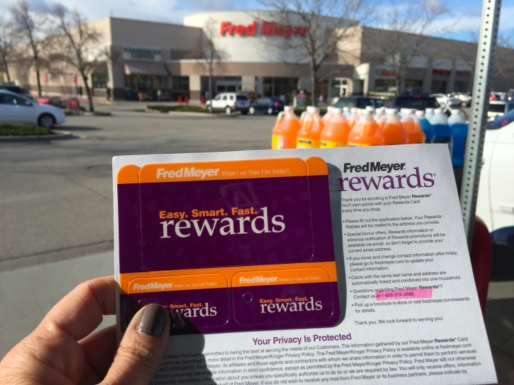 Fred Meyer rewards card held in front of a store.