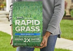 a person holding a bag of grass seed