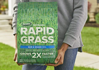 a person holding a bag of grass seed