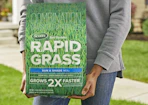 a person holding a bag of grass seed