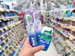 hand holding crest and oral-b items in walgreens