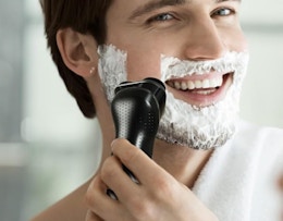 a person using electric shaver on their face
