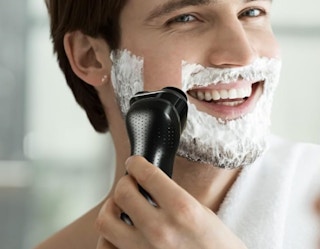 a person using electric shaver on their face