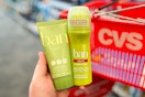 hand holding a tube and stick of ban deodorant in front of cvs shopping basket