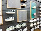 white adidas shoe held by shoe display