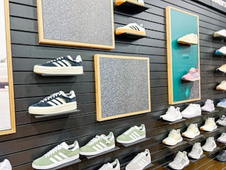 white adidas shoe held by shoe display