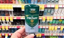 a person holding a stick of deodorant in a store
