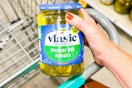 hand holding a jar of vlasic pickes