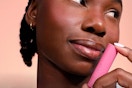 Woman holding lip balm container.