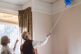 a senior couple dusting a ceiling
