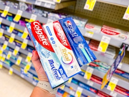 person holding 3 tubes of toothpaste