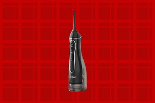 a water flosser on a red background