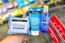 hand holding neutrogena products over a cvs cart