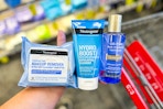 hand holding neutrogena products over a cvs cart