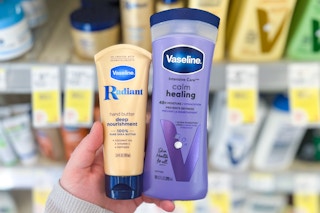hand holding two vaseline products in front of a store shelf