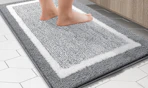 a person standing on a grey and white bathroom rug