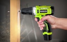 a hand drilling a hole in a piece of wood