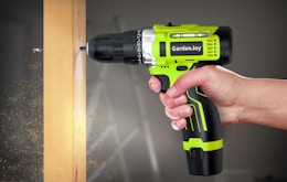 a hand drilling a hole in a piece of wood