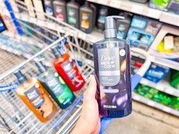 hand holding a bottle of Dove Men+Care body wash with three more bottles in a Walmart cart