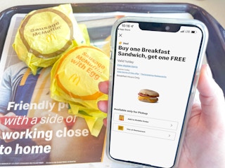 a cellphone with mcdonalds appbeing held in front of 2 mcmuffins
