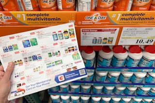Costco coupon book with Kirkland vitamins on the page and the shelf behind it
