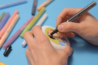 Hands coloring using paint pens.