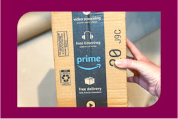 a woman holding an amazon box