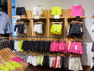A variety of work out shorts hanging on store racks.