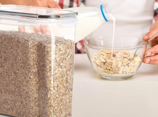 A person pouring milk into a bowl of cereal.
