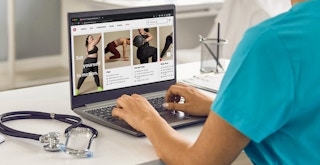 A healthcare worker shopping on the Lululemon website using a laptop