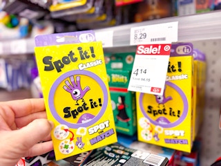 hand holding a spot it party game in front of a target sale tag