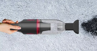 a handheld vacuum cleaning up dirt