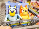 hand pushing walmart cart with bluey and bingo talking plush