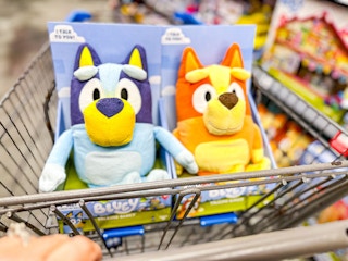 hand pushing walmart cart with bluey and bingo talking plush