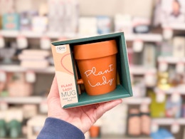 hand holding a plant lady mug in front of target shelves