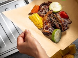 hands holding parchment paper with food on it