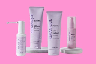 A group of Keranique hair products on a pink background