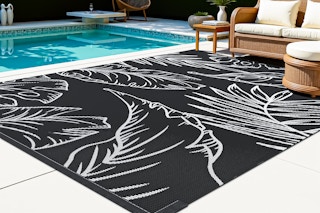 Lifestyle image of outdoor area rug (black & white) next to pool