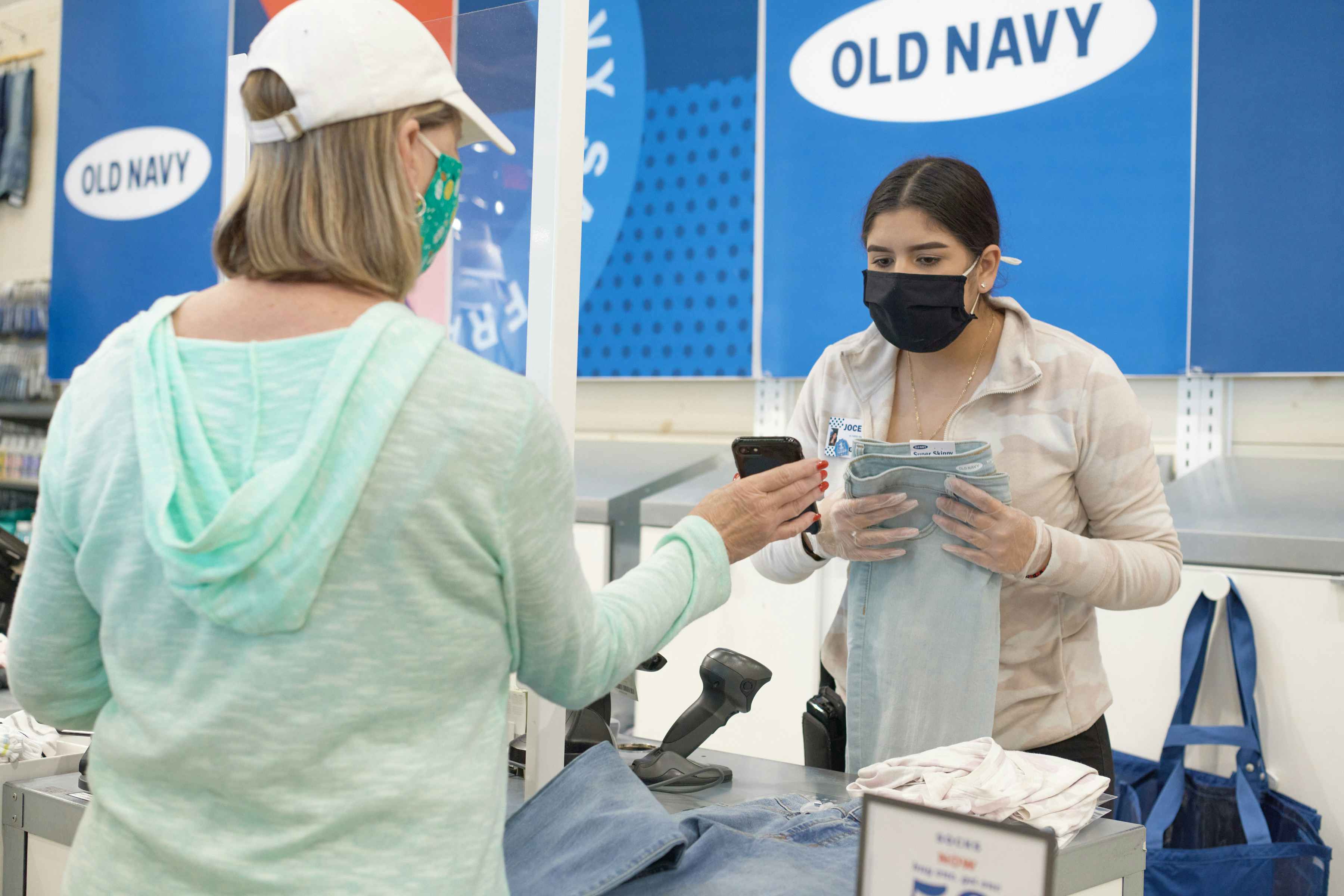 A customer showing an Old Navy employee their cell phone.